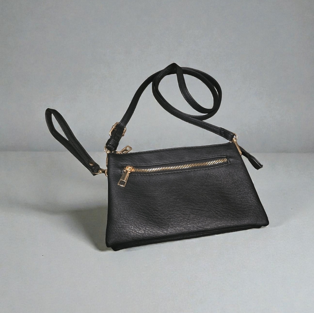 This is a black faux vegan leather crossbody bag with gold-tone hardware. 